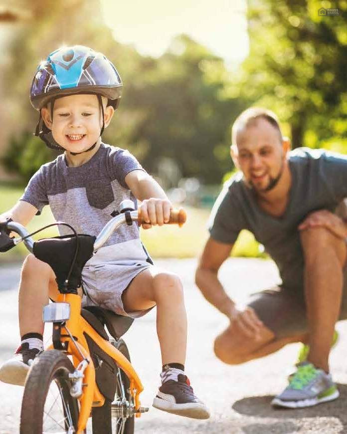 Pai e filho andando de bicicleta em condomínio fechado